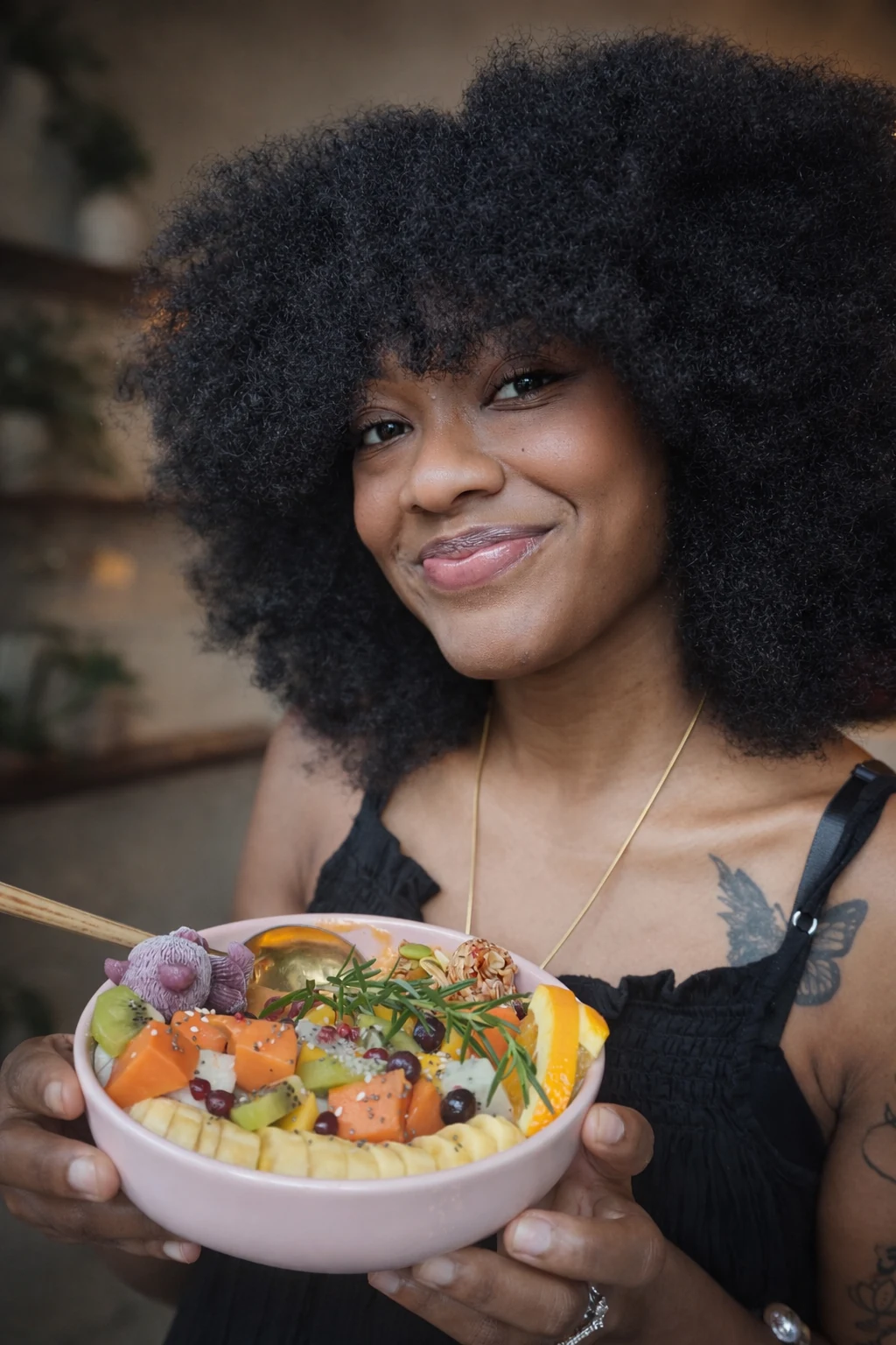 Maleeah Jay smiling, holding a pink bowl of cut fruit